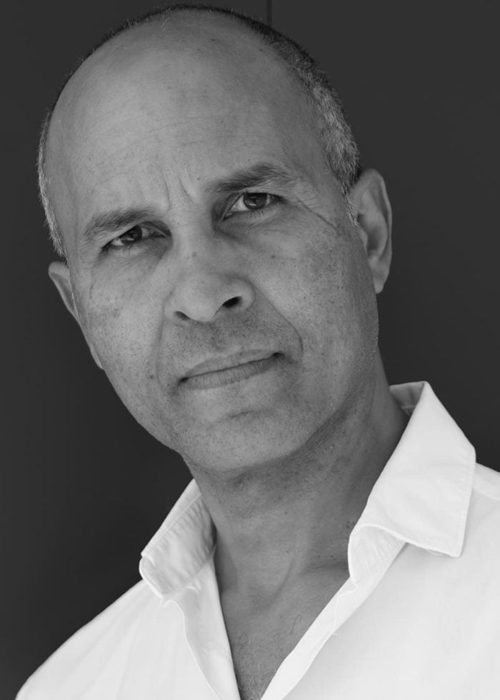 Julio Monge portrait, looking directly at the camera, wearing a white shirt.