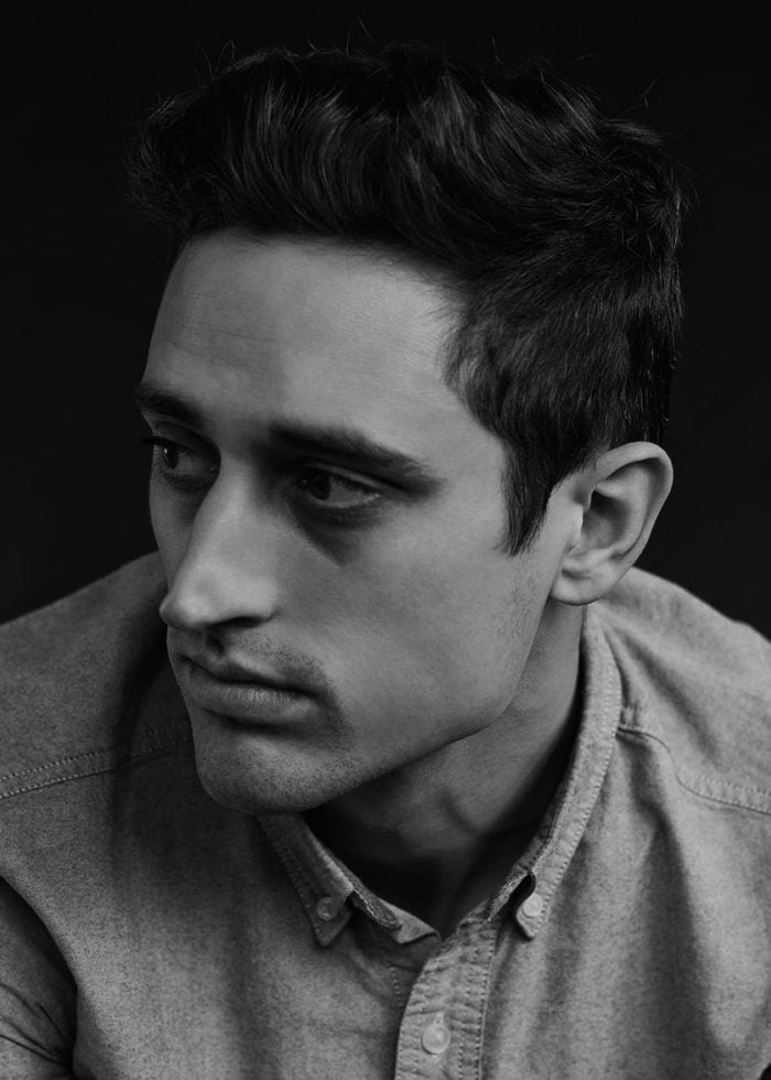 Actor Riz Ahmed in a black and white portrait, looking thoughtful.