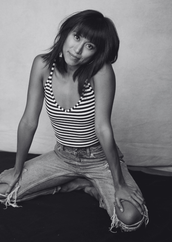 Woman kneeling in ripped jeans and striped tank top