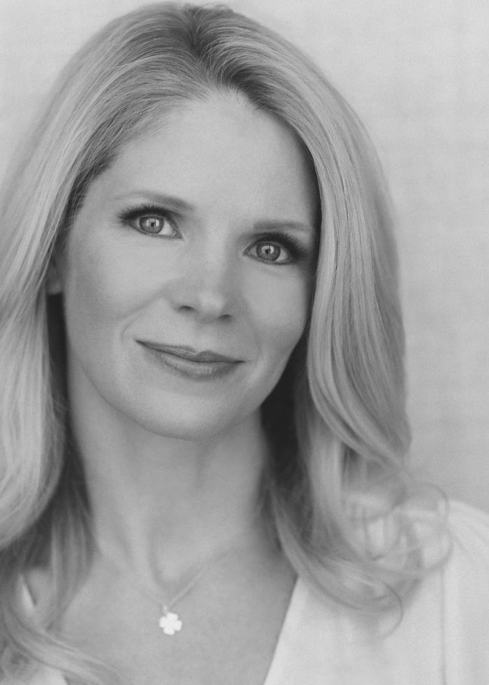 Kelli O'Hara, smiling, looking at the camera, blonde hair, wearing a necklace.