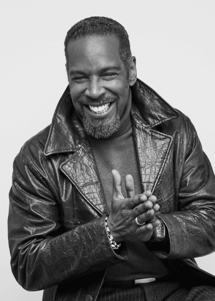 Kevyn Morrow smiling, wearing a leather jacket and turtleneck