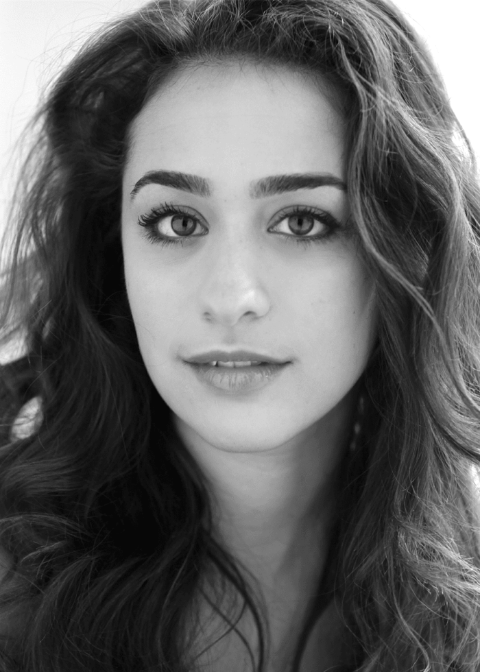 Black and white portrait of Lauren Annunziata with curly hair, looking directly at the camera.