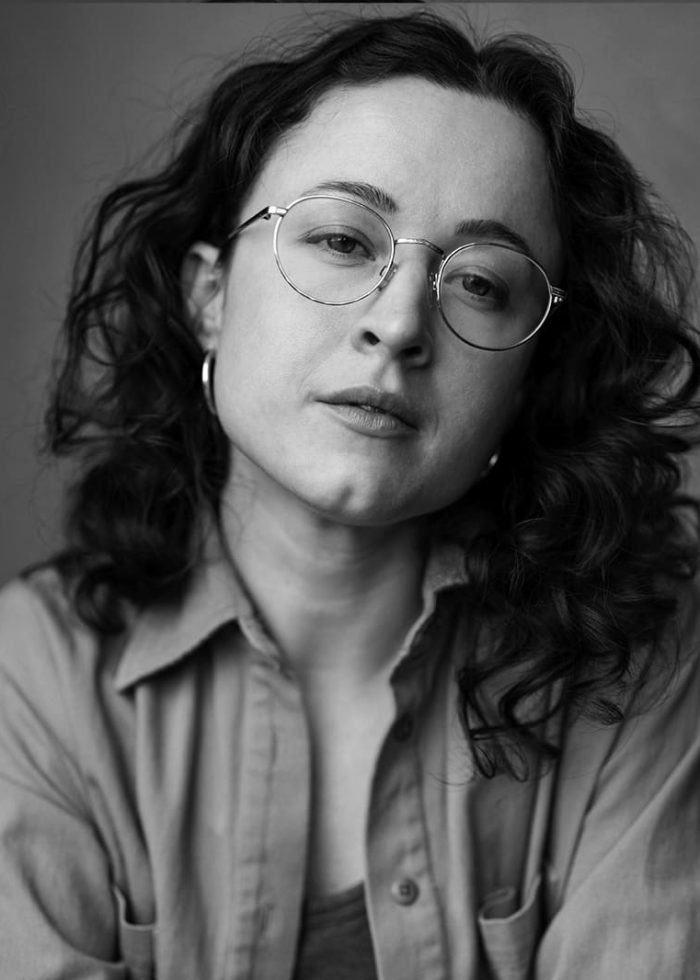 Liz Leimkuhler, headshot: Woman with curly hair and glasses.
