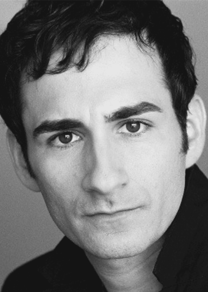 Erik Liberman in a black and white headshot, looking directly at the camera.