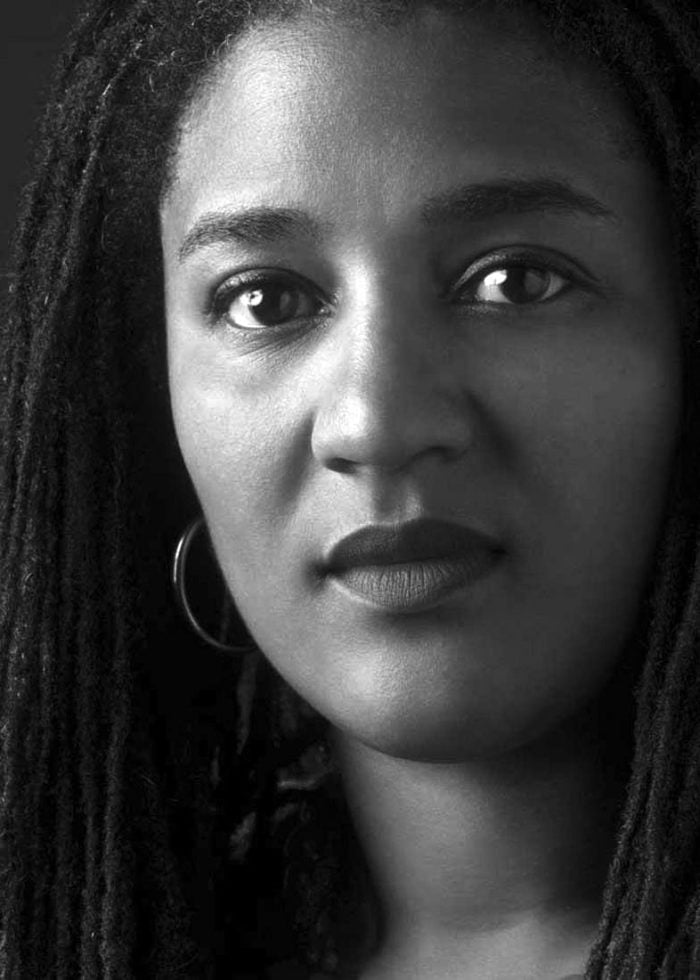 Black and white portrait of Lynn Nottage with dreadlocks, looking directly at the camera.
