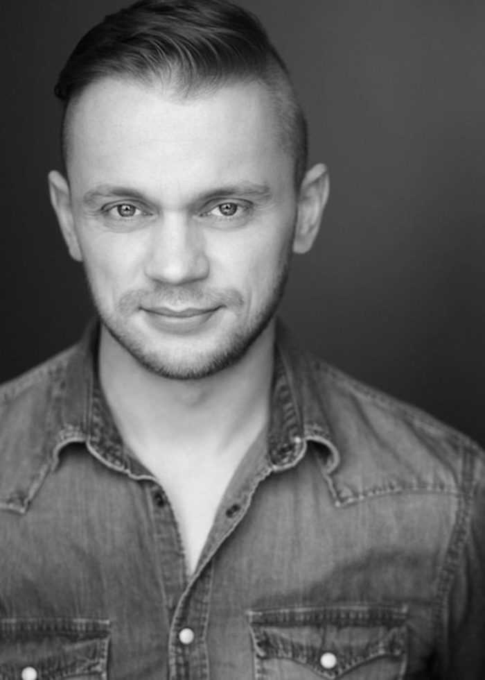 Matt DeAngelis, headshot in black and white, wearing denim shirt and short haircut.