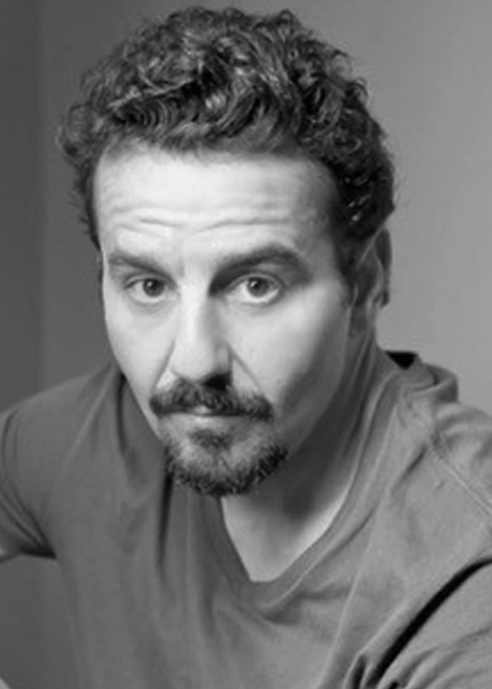 Max Casella in a black and white portrait, looking at the camera.