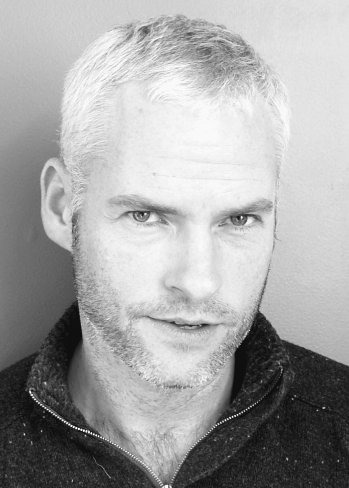 Martin-McDonagh-by-Euan-Kerr-Minnesota-Public-Radio Portrait of a man with gray hair and a beard, looking directly at the camera.