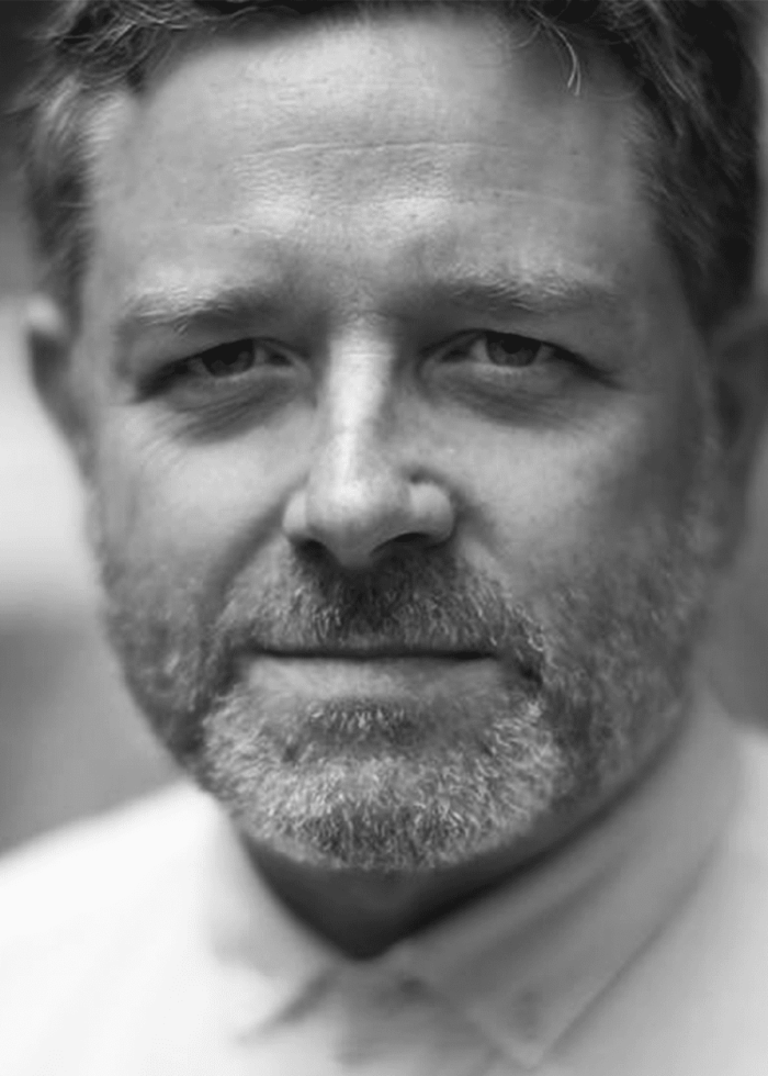 Matthew-Dunster-headshot Close-up portrait of Matthew Dunster, a man with a beard, looking at the camera.