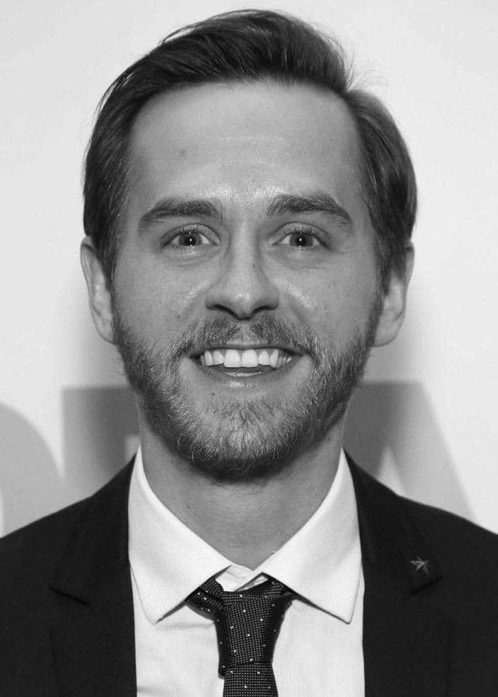 Danny Mefford smiling in a suit, black and white portrait