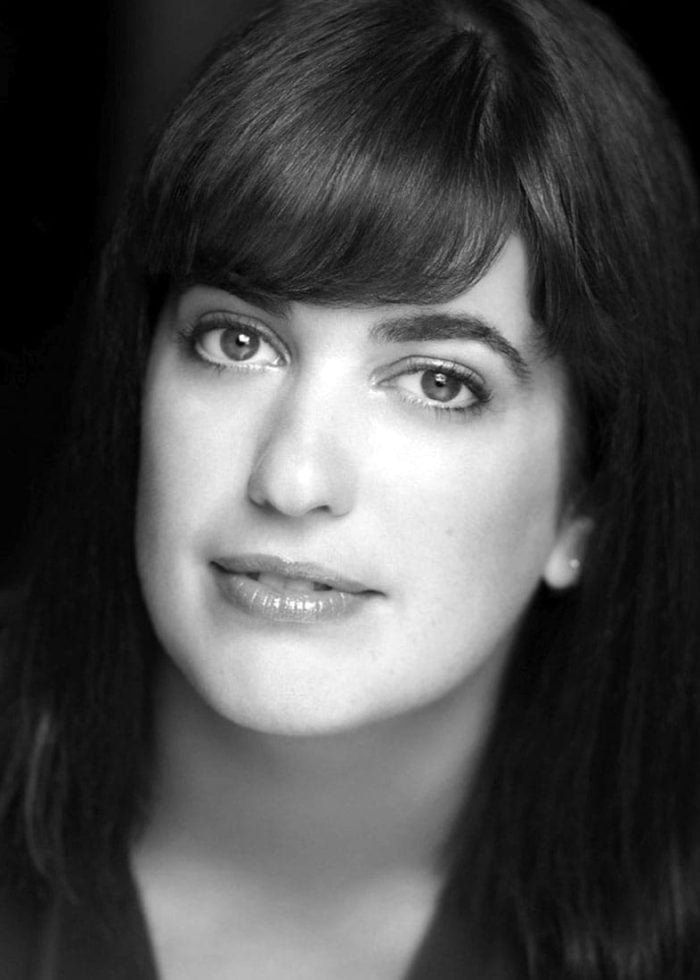 Megan Hill, headshot, looking at the camera with dark hair and bangs.