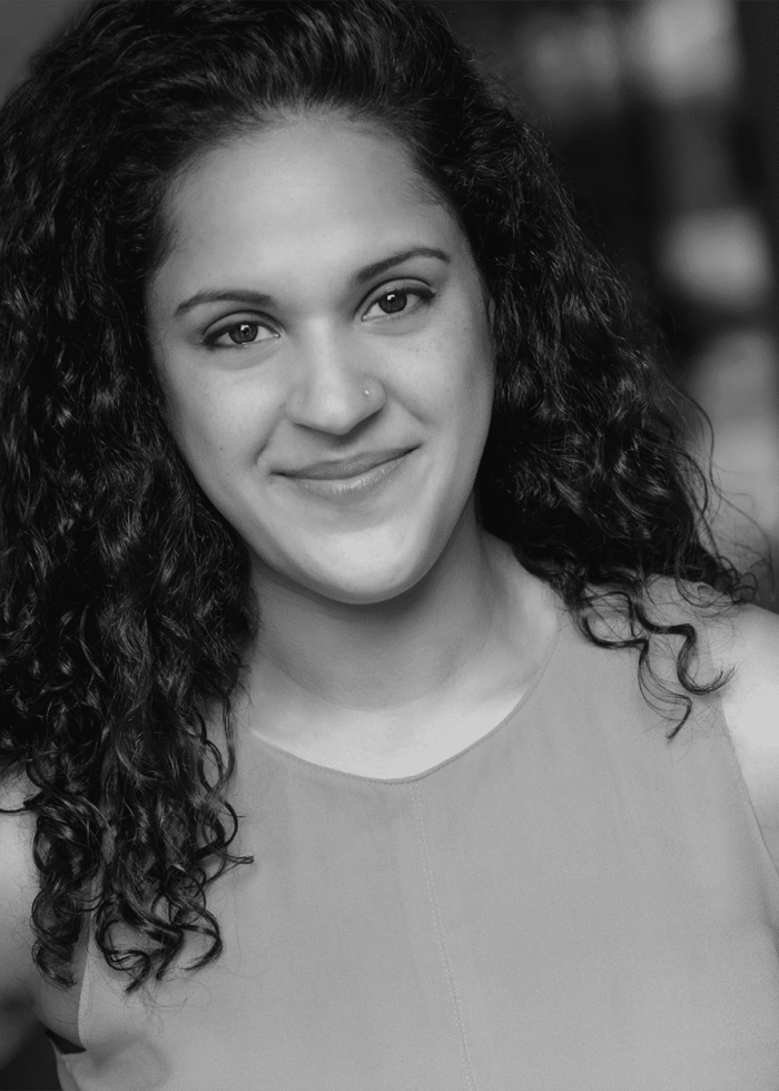 Melissa Crespo smiling, with curly dark hair and a nose ring.