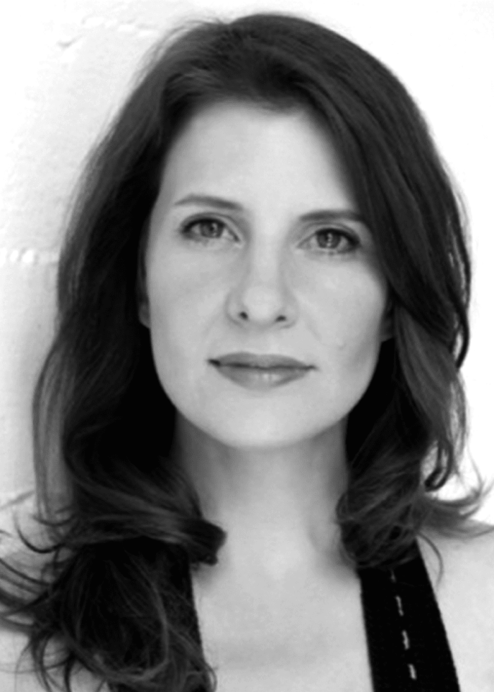 Portrait of a woman with dark hair, looking at the camera.