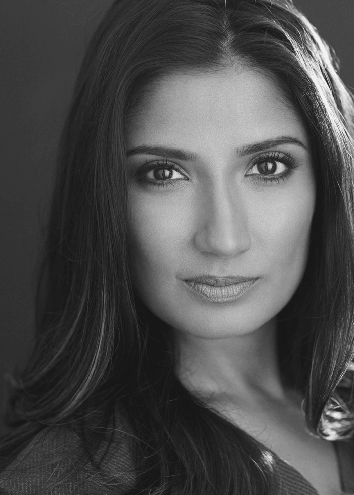 Close-up portrait of a woman with long dark hair, looking directly at the camera.