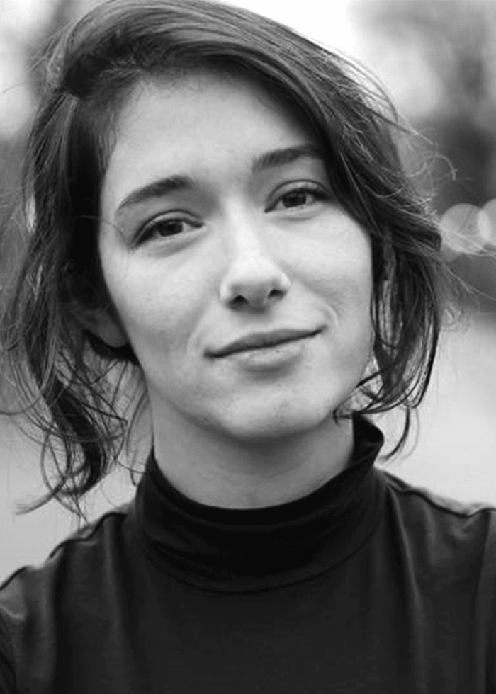 Mina Walker, a young woman with short dark hair, smiles at the camera.