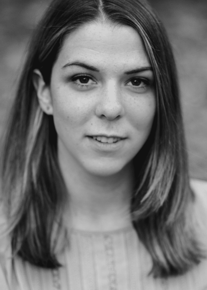 Portrait of Molly Collier, looking directly at the camera, in black and white.