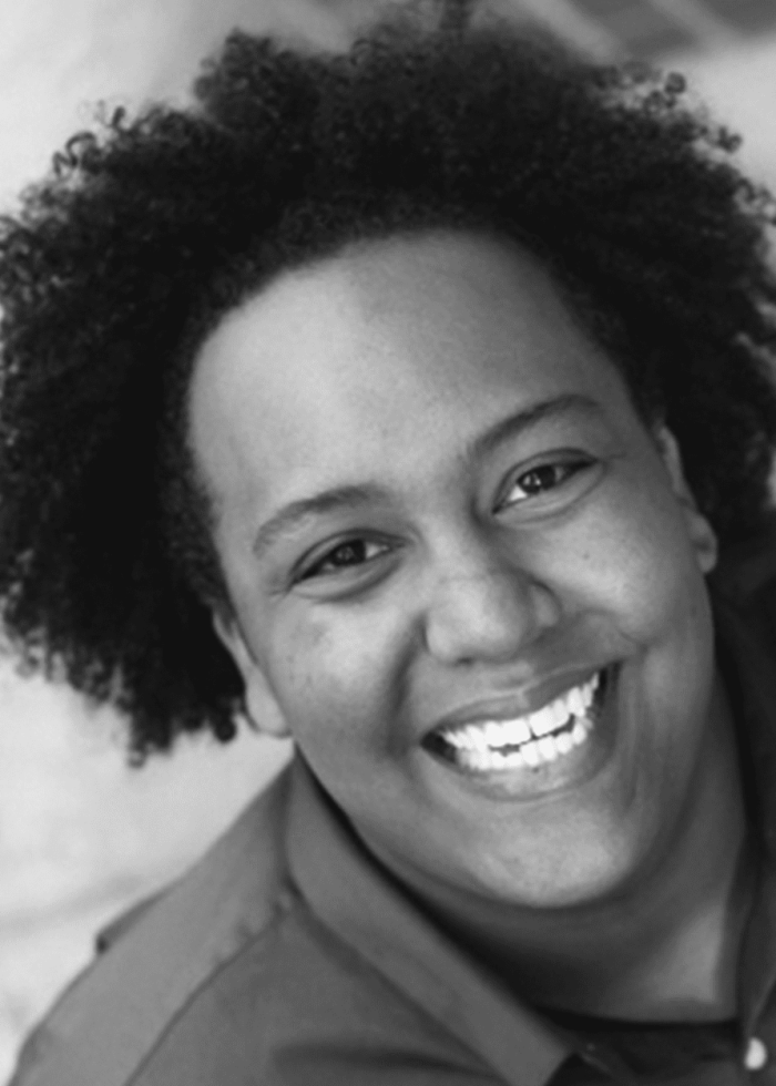 Person with curly hair smiling.