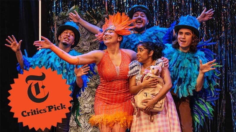 Cast of "El Otro Oz" musical, a Critics' Pick, in colorful costumes. The New York Times logo is visible.