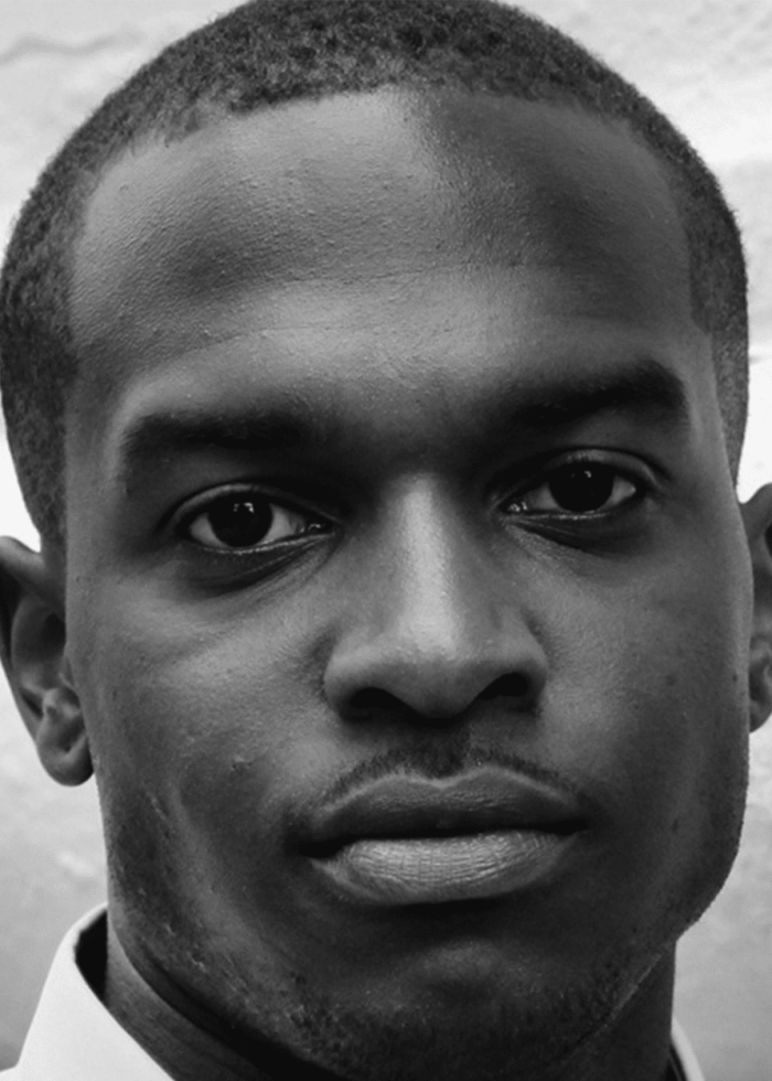 Close-up portrait of a Black man with a serious expression.