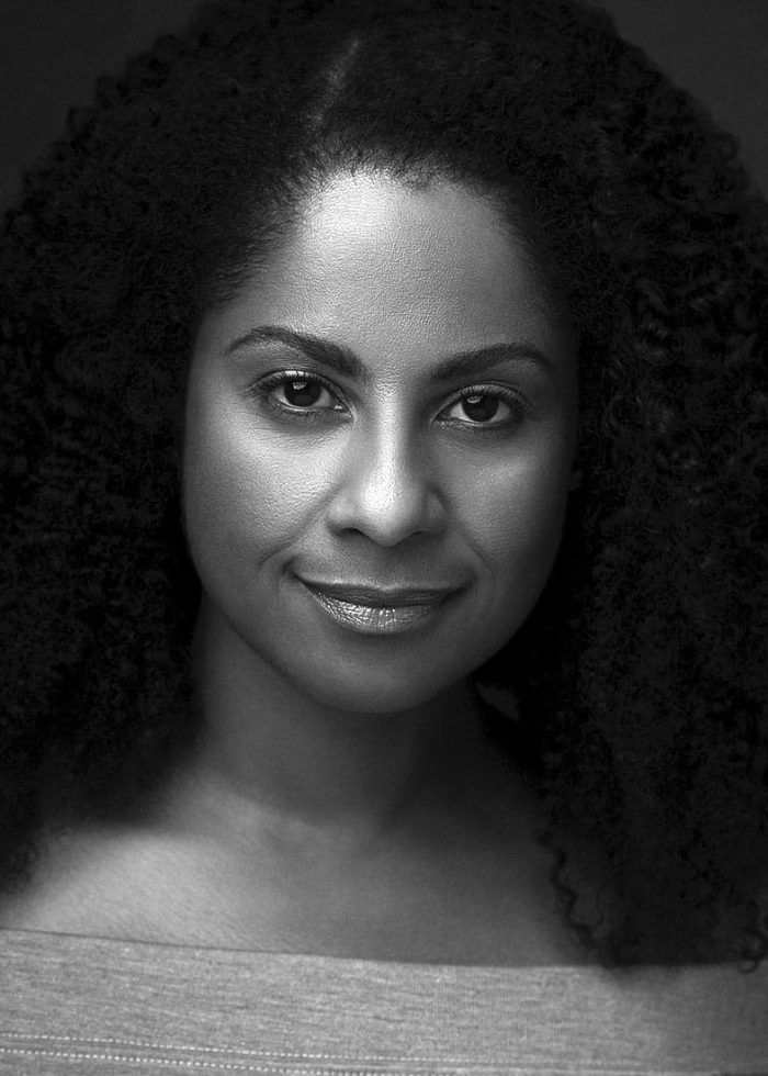 Headshot of Nicole Lewis, smiling with curly hair.