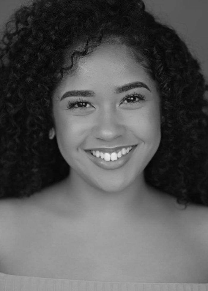 Beautiful woman with curly hair smiles brightly, portrait