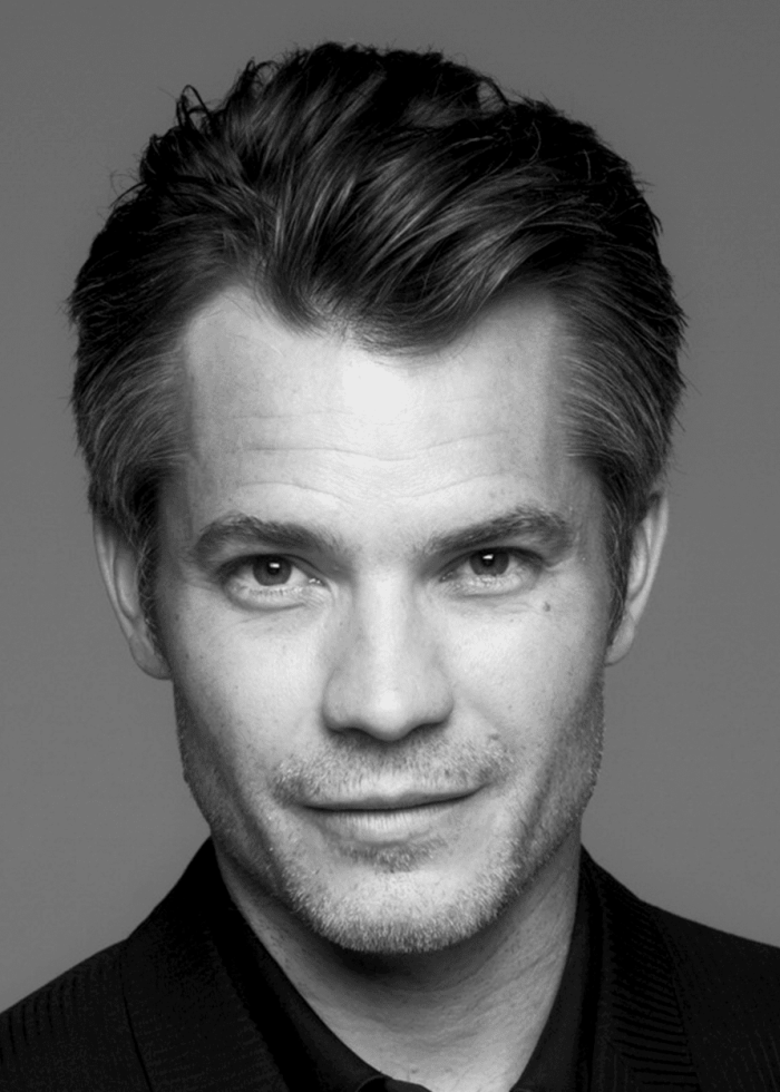 Timothy Olyphant looking directly at the camera in a black and white portrait.