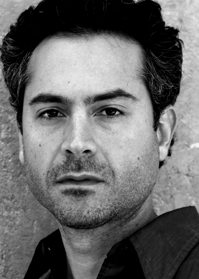 Omar Metwally portrait, black and white, looking directly at the camera