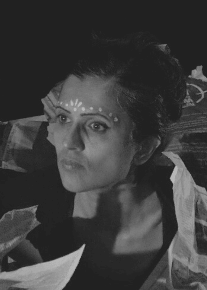 Woman with ornate face paint, gazing thoughtfully. Parijat Desai portrait.