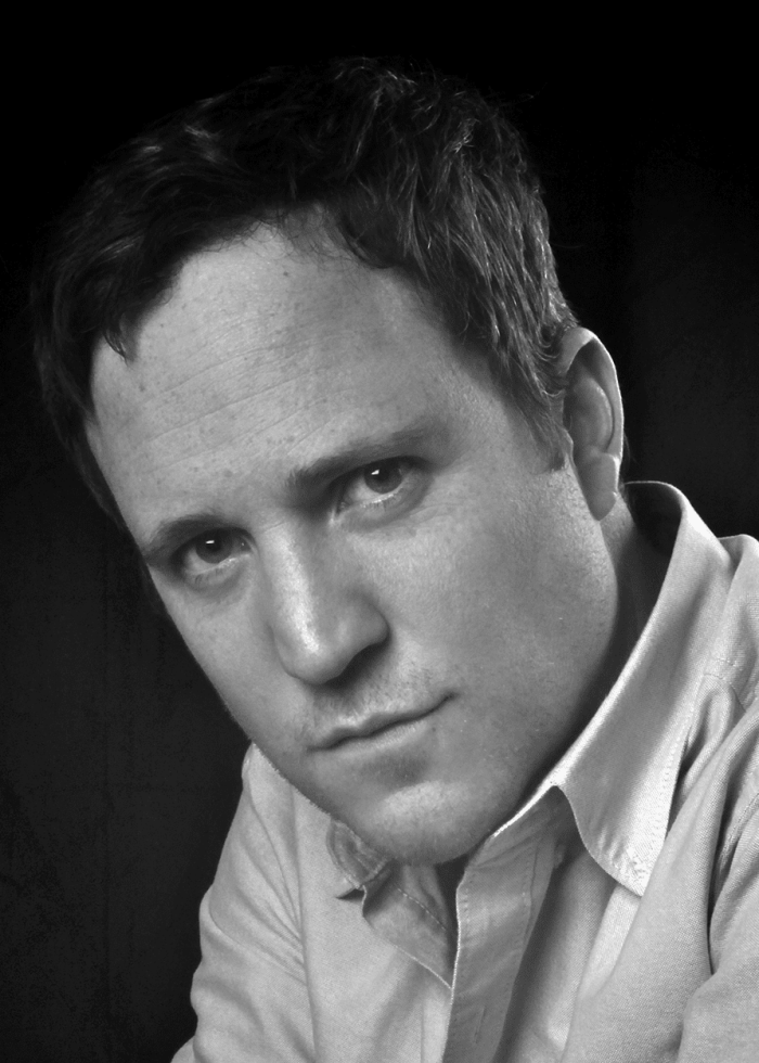 Patch Darragh looking at the camera in a black and white portrait.