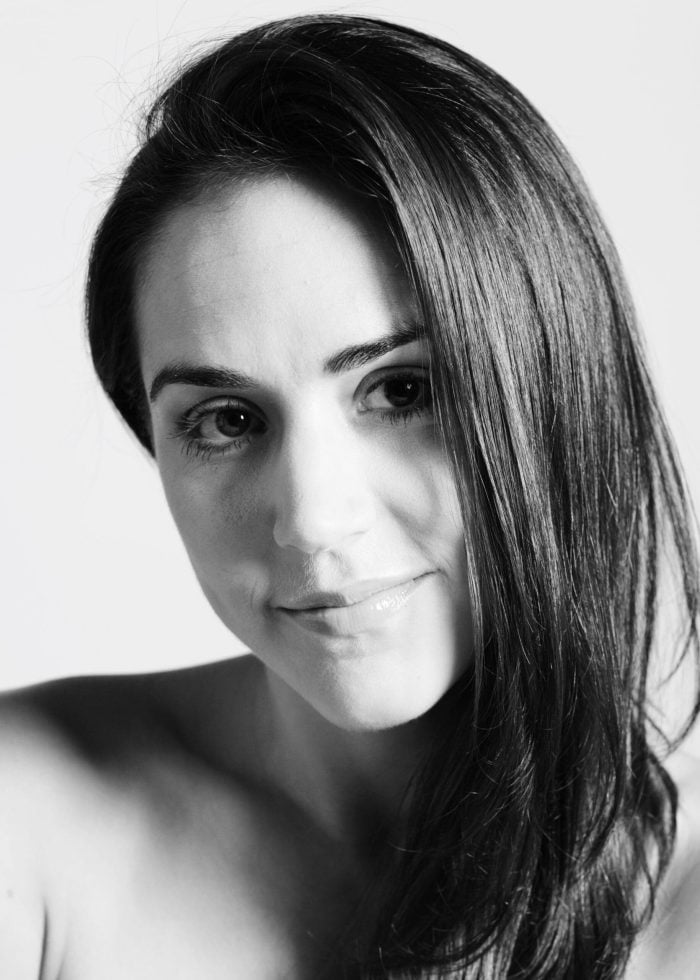 Black and white portrait of Patricia Delgado, smiling at the camera.