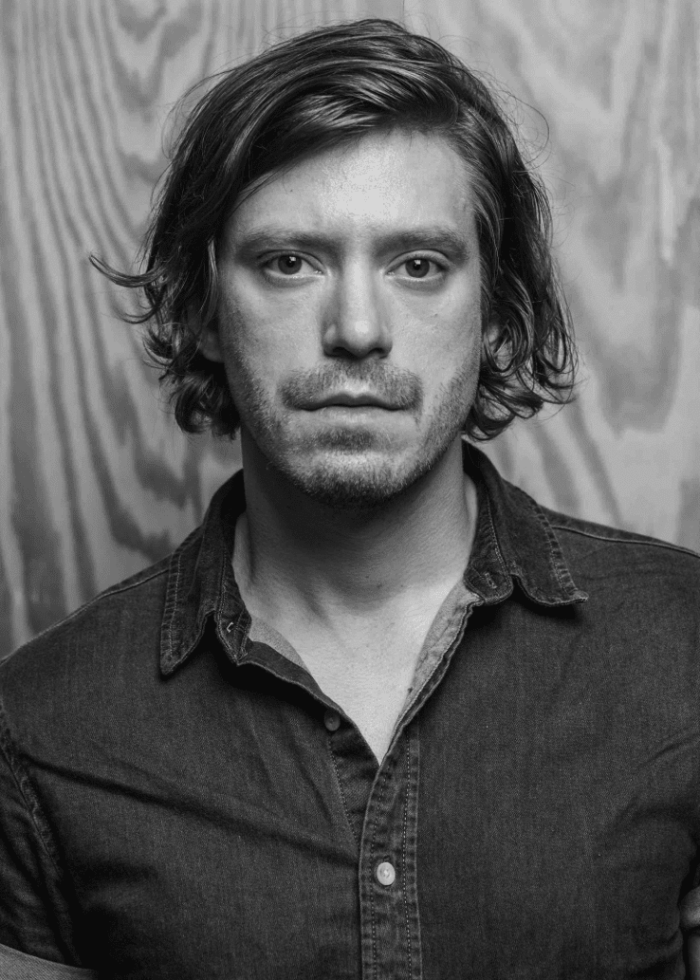 Patrick Vaill in a black and white portrait, looking directly at the camera.