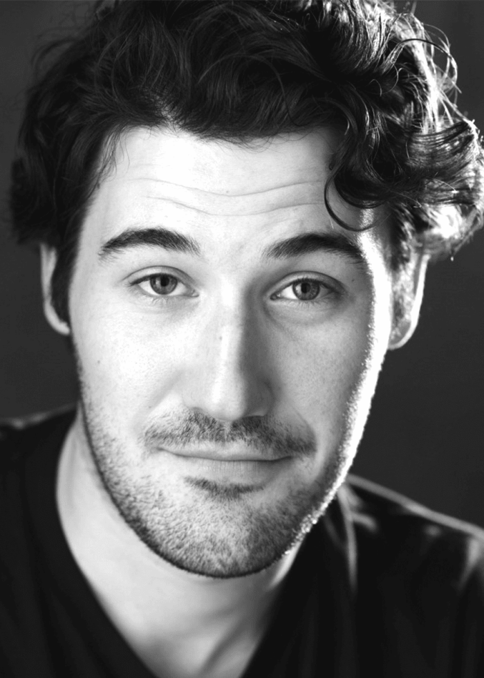 Black and white headshot of Paul Hinkes, a man with dark hair and a beard.