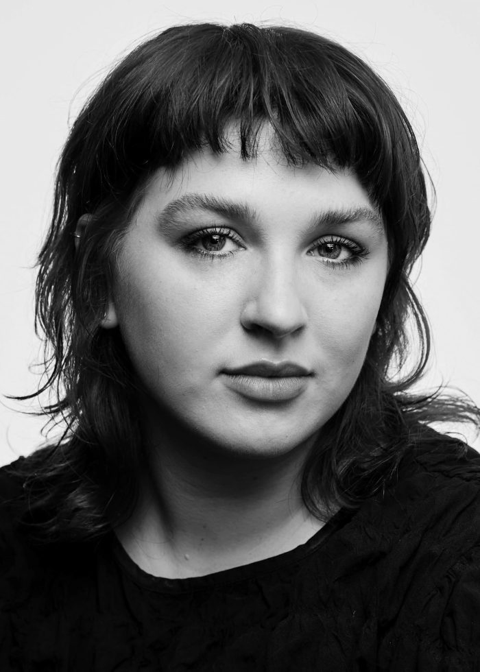 Portrait of a young woman with short hair, looking directly at the camera.