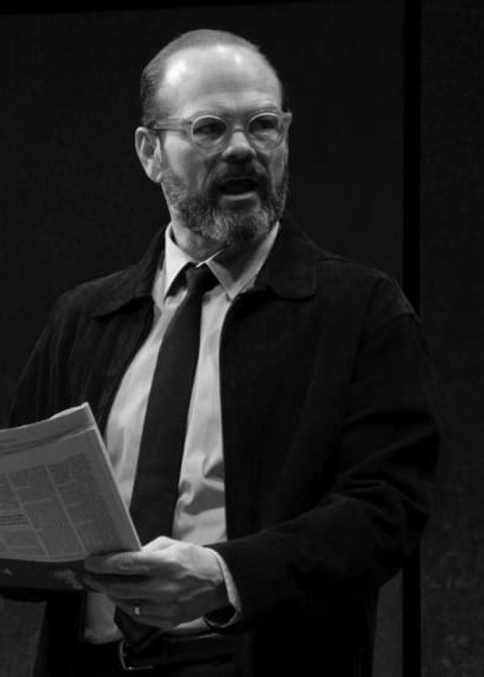 Actor in David Mamet's 'The Penitent' holding a newspaper, Off Broadway play review.