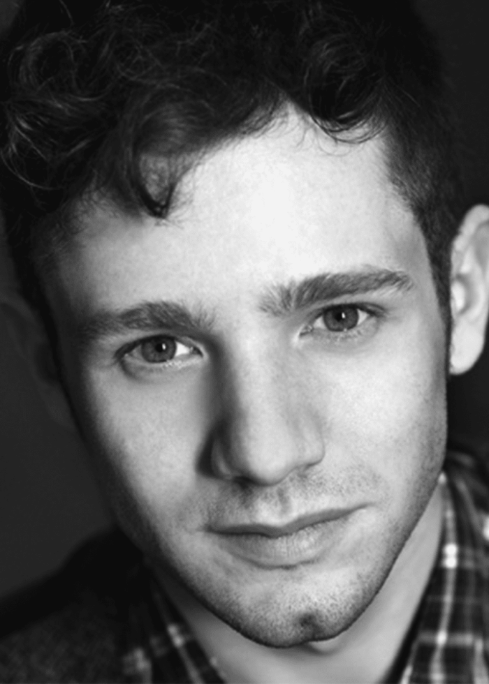 Chris Perfetti headshot: young man with dark curly hair and a subtle smile.