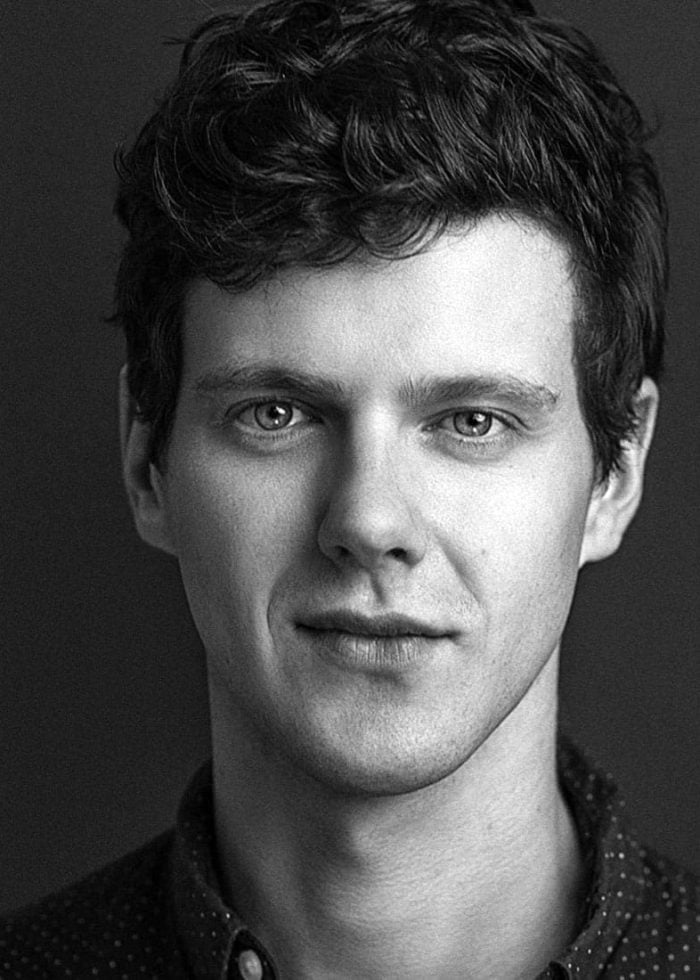 Peter Mark Kendall in a black and white portrait, looking directly at the camera.