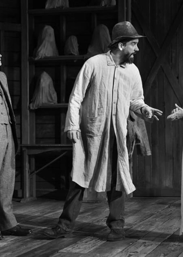 Actors in a scene from Doug Wright’s ‘Posterity.’ Man in coat speaks to woman in draped garment.