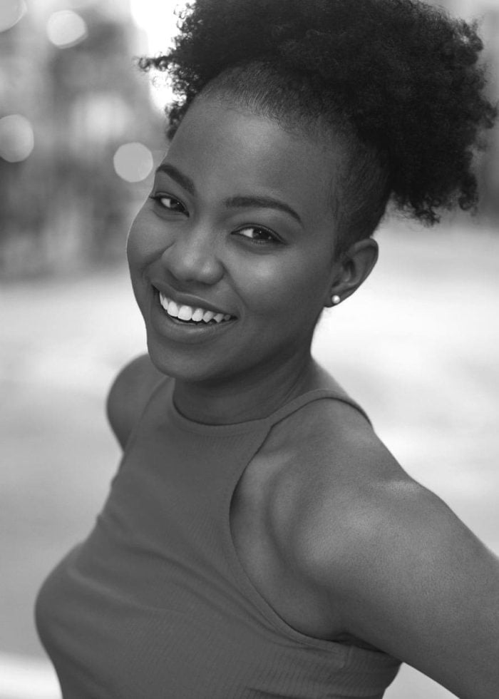 Smiling Renika Williams with her hair up, looking at the camera.