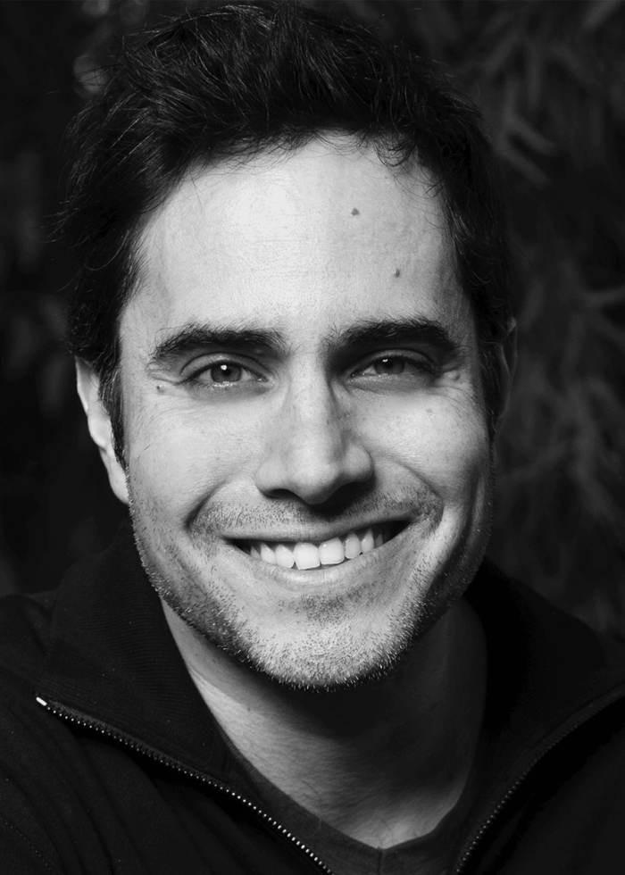 Rajiv Joseph smiles, portrait in black and white