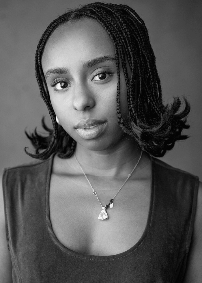 Renée-Nicole Powell, a young woman with braided hair, wearing a necklace.