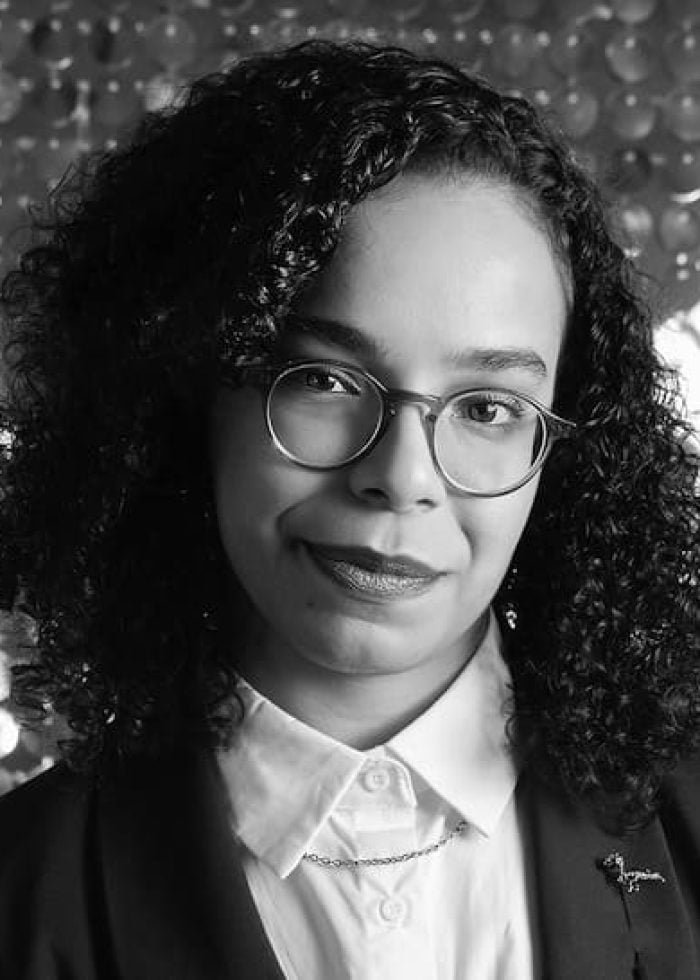 Banna Desta smiling, wearing glasses and blazer