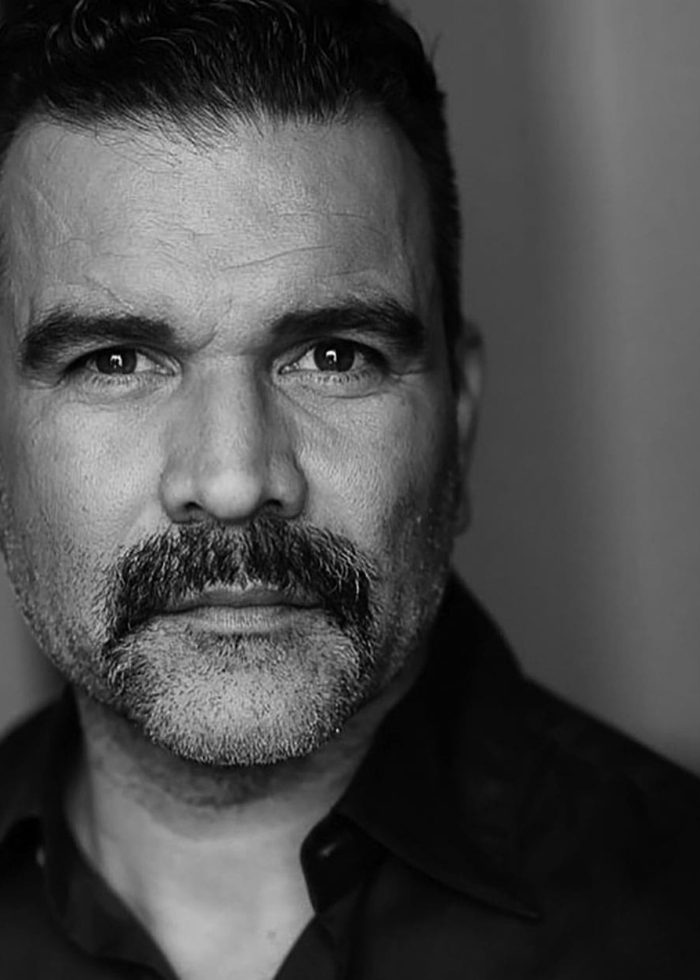 Ricardo Chavira portrait: actor with a distinguished mustache in black and white.