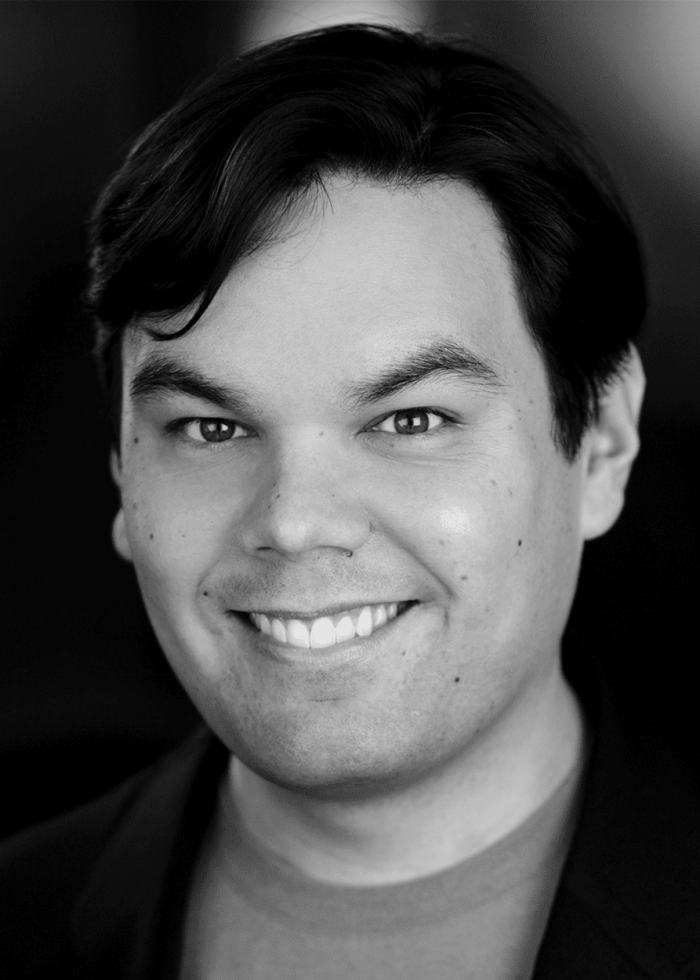 Headshot of Robert Lopez smiling, black and white