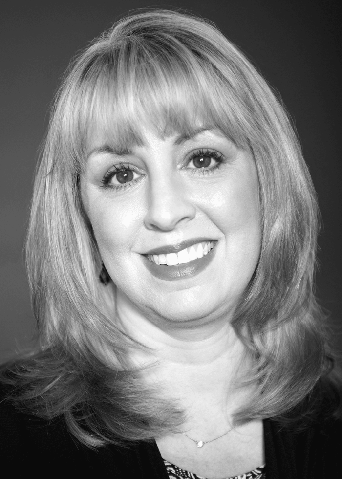 Rachel Rockwell, smiling with blonde hair and red lipstick