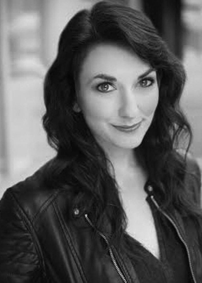 Rori Nogee, actress, smiling in a black leather jacket