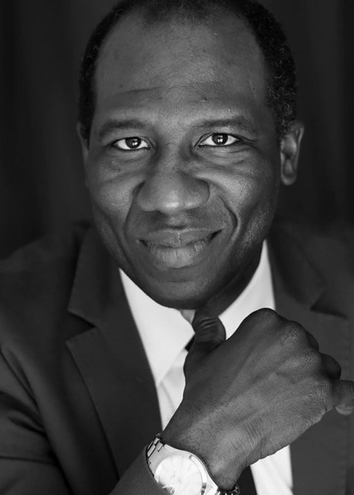 Russell G. Jones, smiling confidently in a suit, looking directly at the camera.