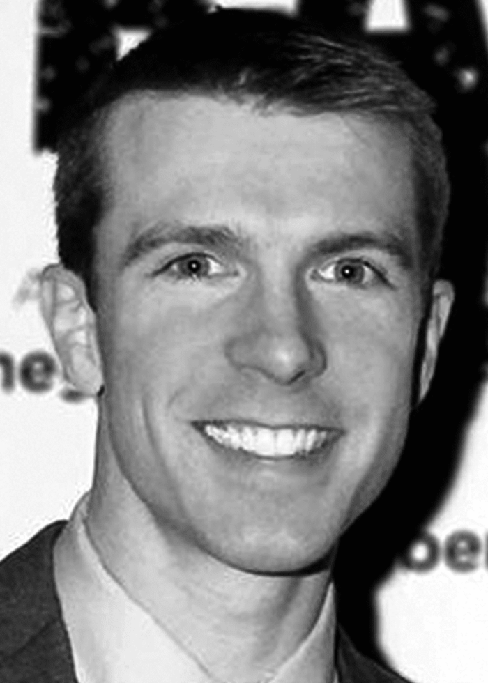 Scott Elmegreen smiling at the camera in black and white