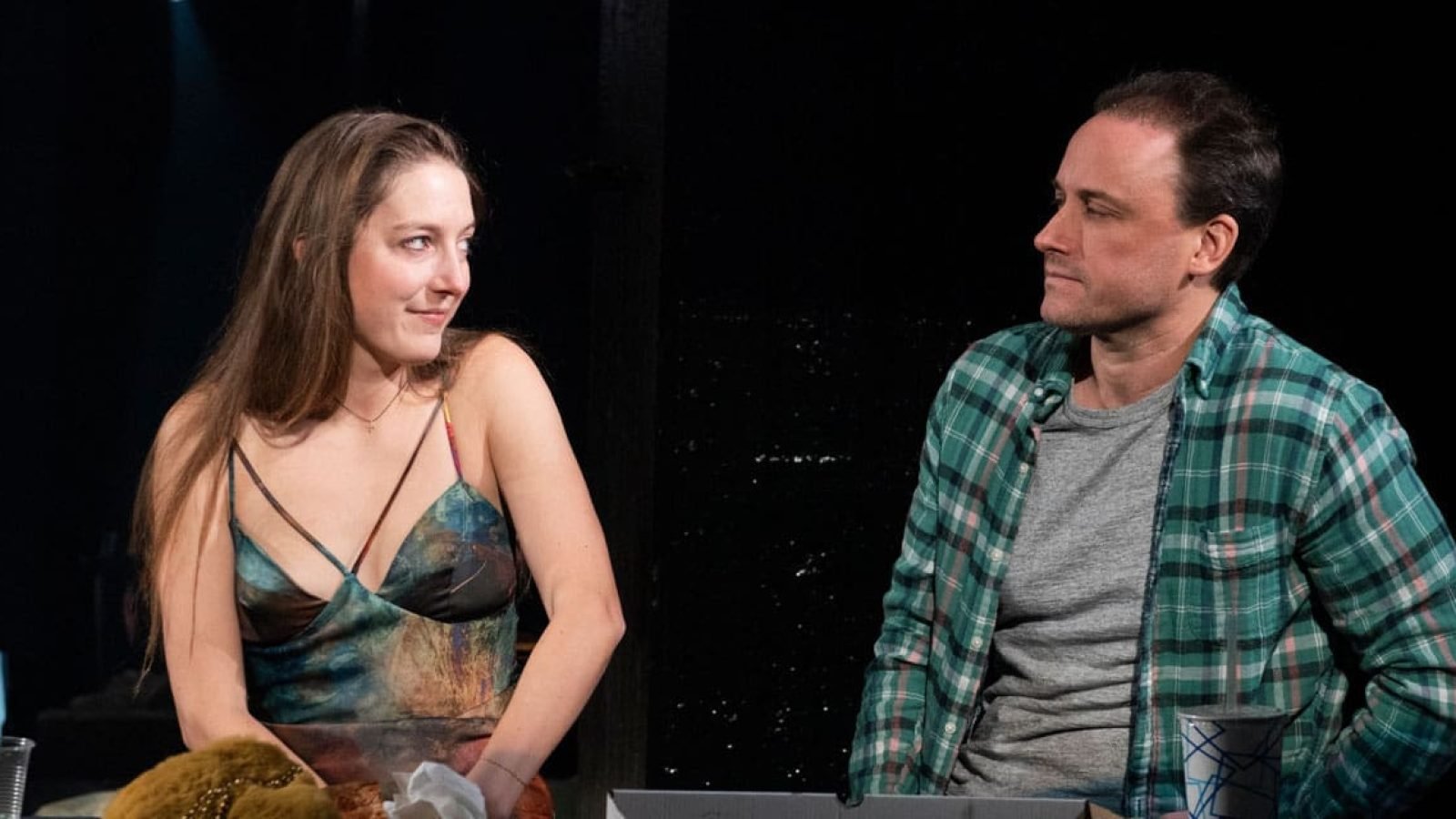 A man and woman sit opposite each other, sharing a quiet moment. Shhh.