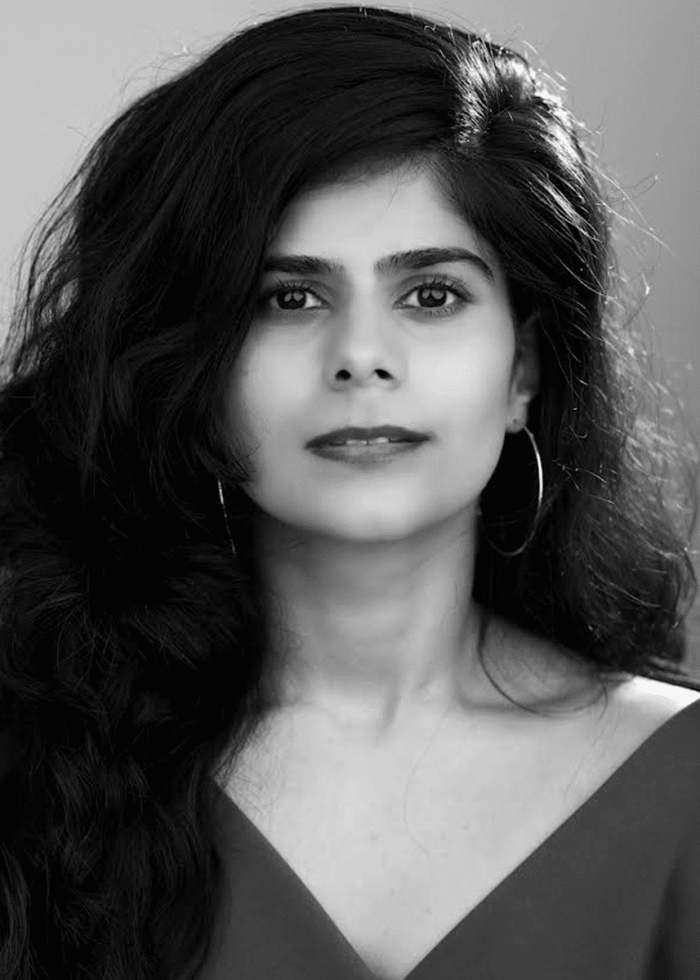 Black and white portrait of a woman with long, wavy hair and hoop earrings.