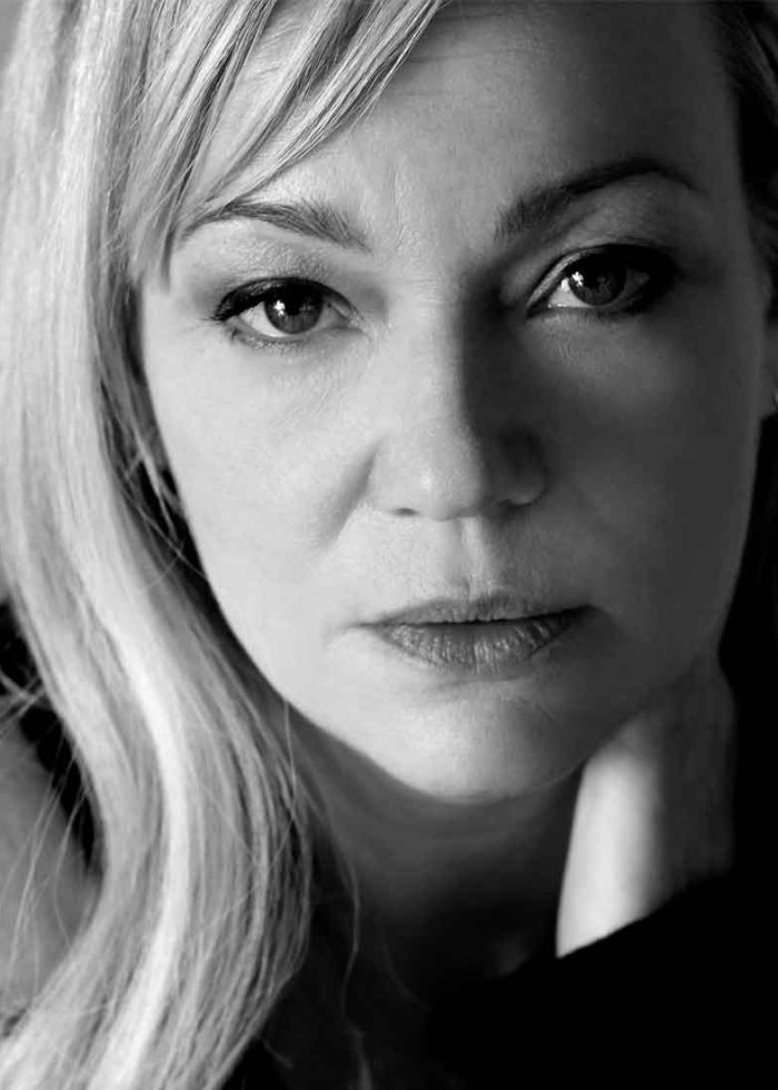 Samantha Mathis looking directly at the camera, black and white portrait.